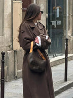 Manteau mi-long femme noir avec ceinture et boutons, adapté pour les saisons intermédiaires et les tenues décontractées.