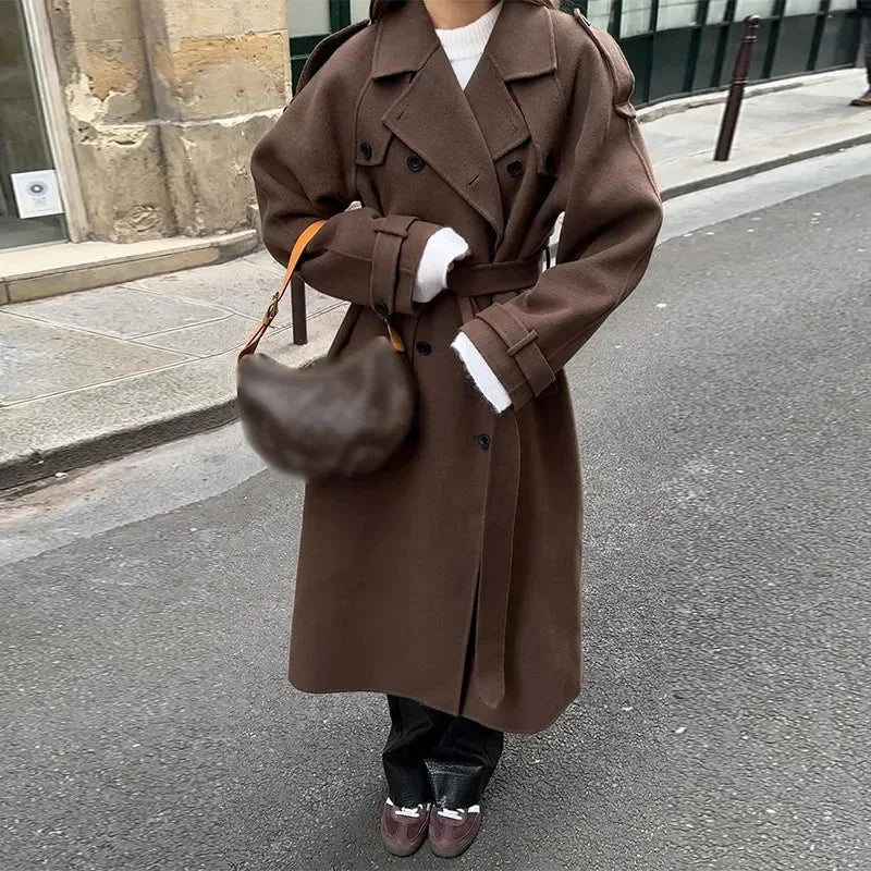 Manteau mi-long en laine, taillé avec ceinture et boutons, offrant une coupe élégante et confortable pour les jours frais.
