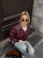 Kurzer bordeauxfarbener Trenchcoat für Frauen aus leichtem Material, mit Taillengürtel und eleganten Reverskragen.