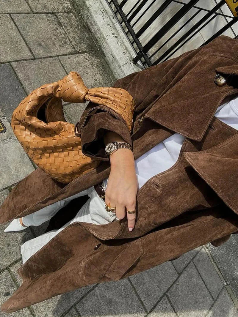 Manteau trench femme marron avec ceinture et revers, conçu pour les journées plus fraîches.