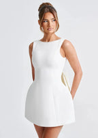 Mini robe dos nu ajustée avec grand nœud, ornée de perles, en tissu léger idéal pour les soirées.