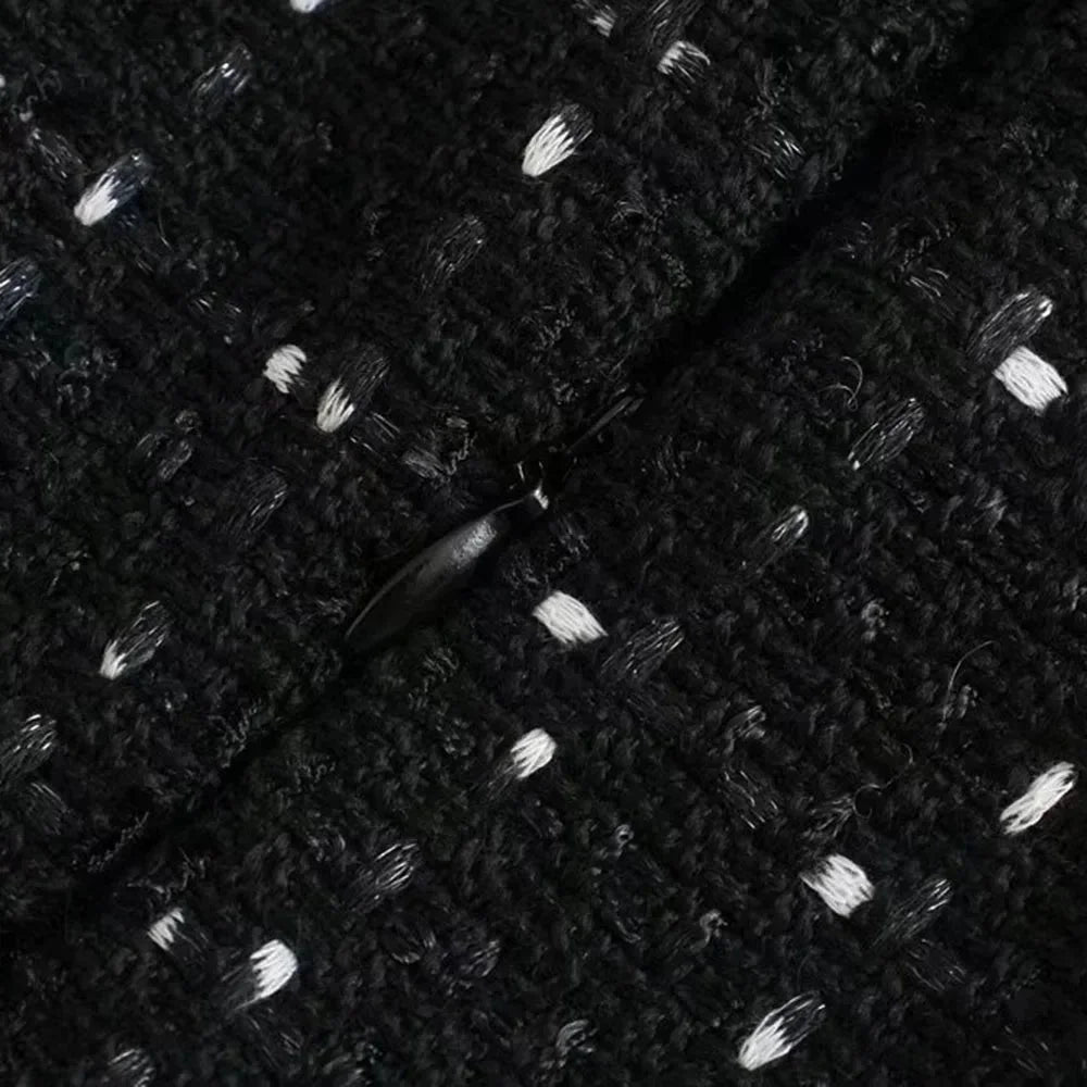 Mini robe noire perlée avec découpes, manches épaules nues, tissu léger et détails en perles pour un look élégant.