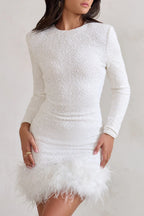 Mini robe noire pour femme, manches longues, ourlet orné de plumes, en tissu fluide.