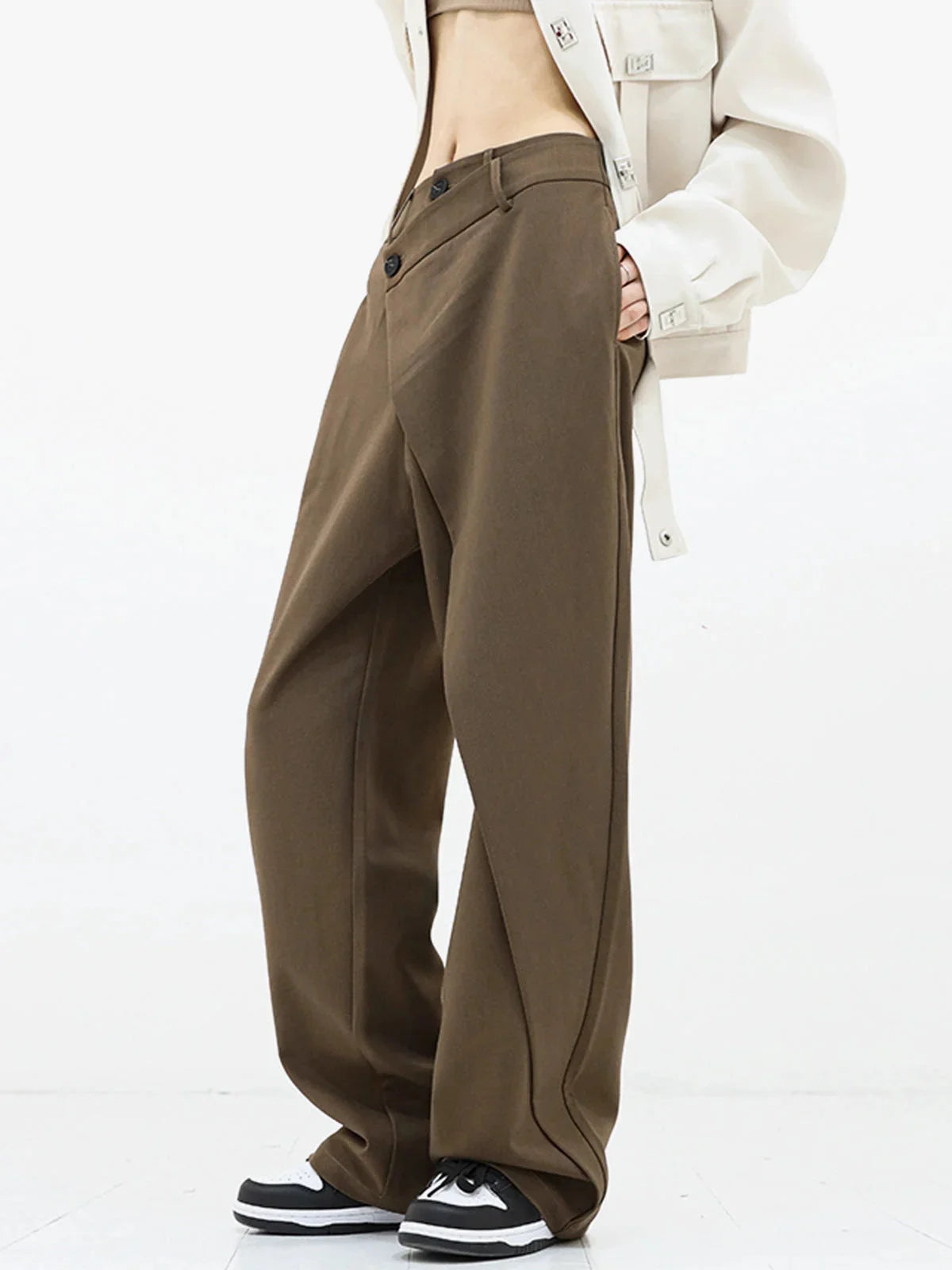 Pantalon femme gris à coupe large, bouton asymétrique et design superposé, en tissu léger et respirant.