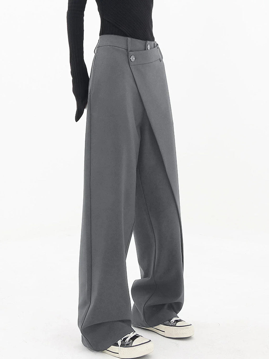Pantalon femme gris à coupe large, boutons asymétriques et design superposé.