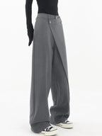 Pantalon femme gris à coupe large, boutons asymétriques et design superposé.
