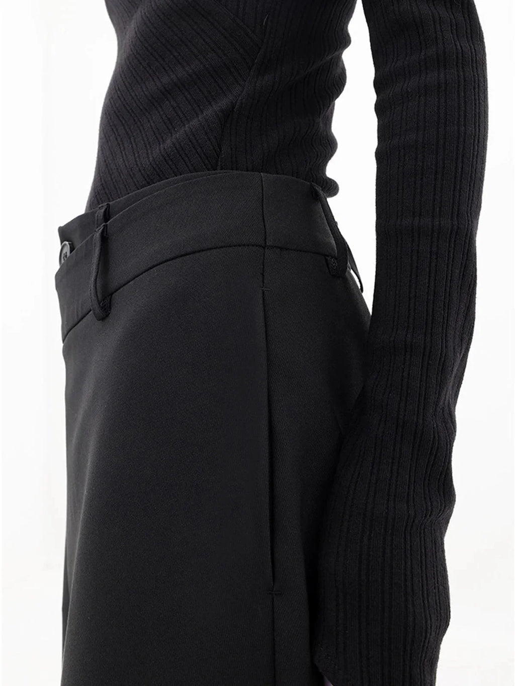 Pantalon femme noir à coupe large, design superposé avec bouton asymétrique en tissu léger.