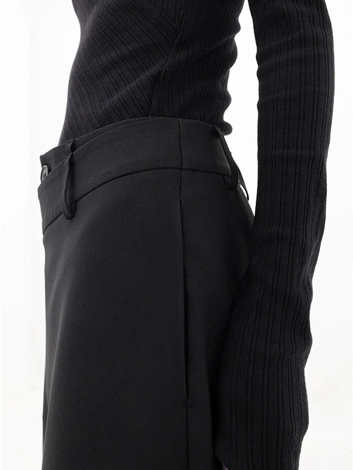 Pantalon femme noir à coupe large, design superposé avec bouton asymétrique en tissu léger.