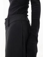 Pantalon femme noir à coupe large, design superposé avec bouton asymétrique en tissu léger.