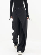 Pantalon femme noir à coupe large, avec bouton asymétrique et en tissu léger et respirant.