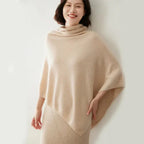 Poncho beige pour femmes en tissu doux, avec coupe asymétrique et franges.