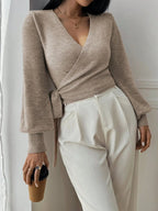 Pull cache-cœur beige pour femme en laine douce, avec ceinture à nouer ajustable à la taille.