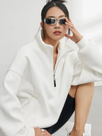 Oversize Damen-Pullover mit halbem Reißverschluss, aus weichem, atmungsaktivem Material in sauberem Weiß.