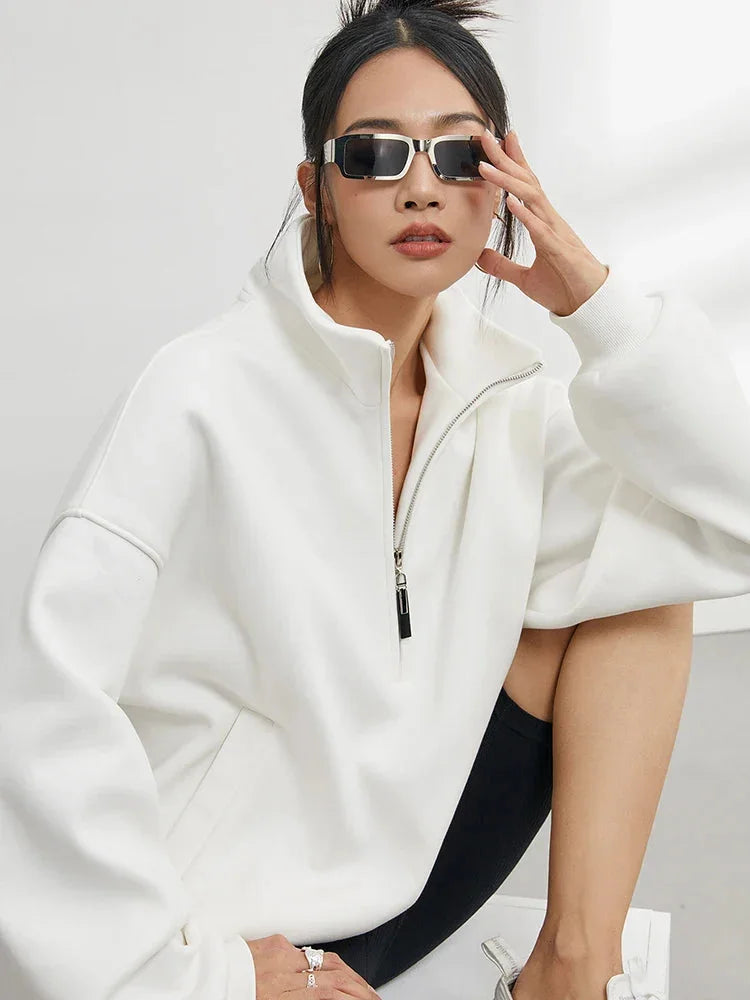 Oversize Damen-Pullover mit halbem Reißverschluss, aus weichem, atmungsaktivem Material in sauberem Weiß.