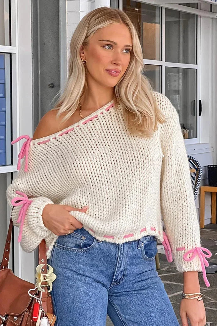 Pull femme asymétrique blanc avec attaches, conçu pour un style décontracté.