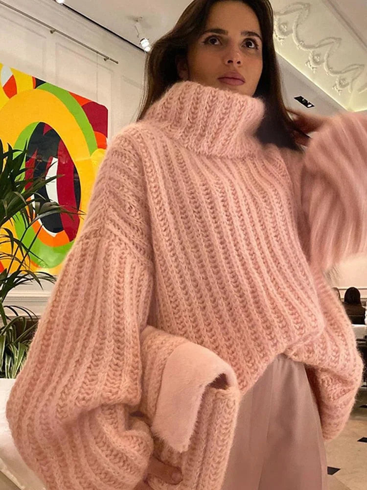 Pull femme rose col roulé, manches larges, en matière douce pour un confort quotidien.