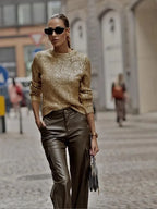 Pull femme doré à manches longues, design scintillant en matière douce, adapté à diverses occasions.