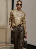 Pull femme doré à manches longues en tissu scintillant, design festif adapté aux occasions spéciales.
