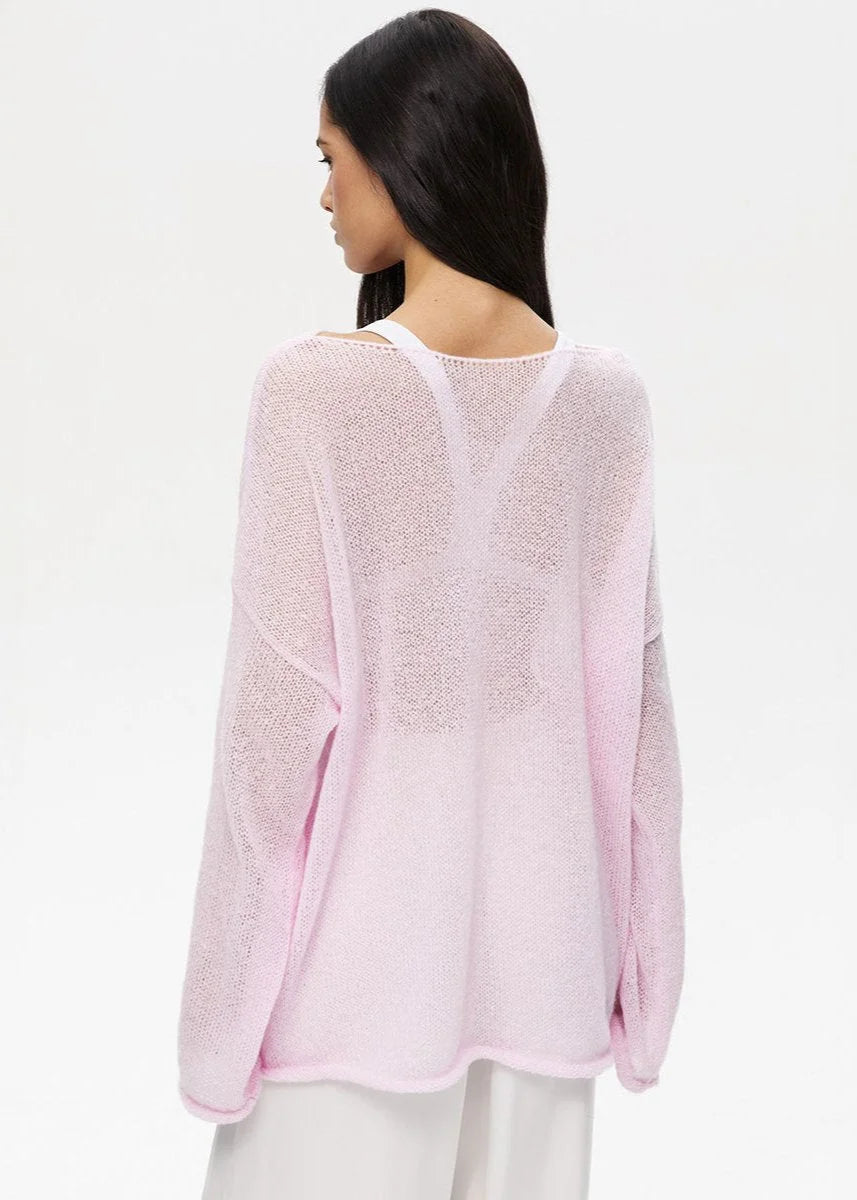 Pull femme léger en maille transparente rose, à manches longues et coupe aérée.