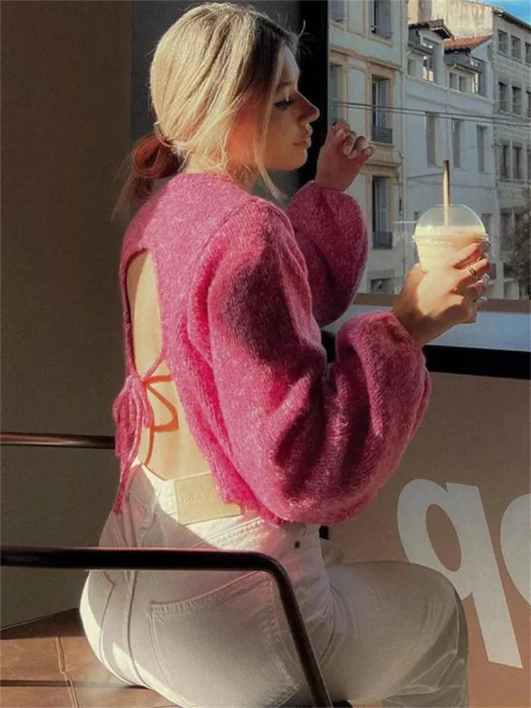 Rosa Damenpullover mit modernem offenen Rücken, aus weichem Material, ideal für legere Outfits.