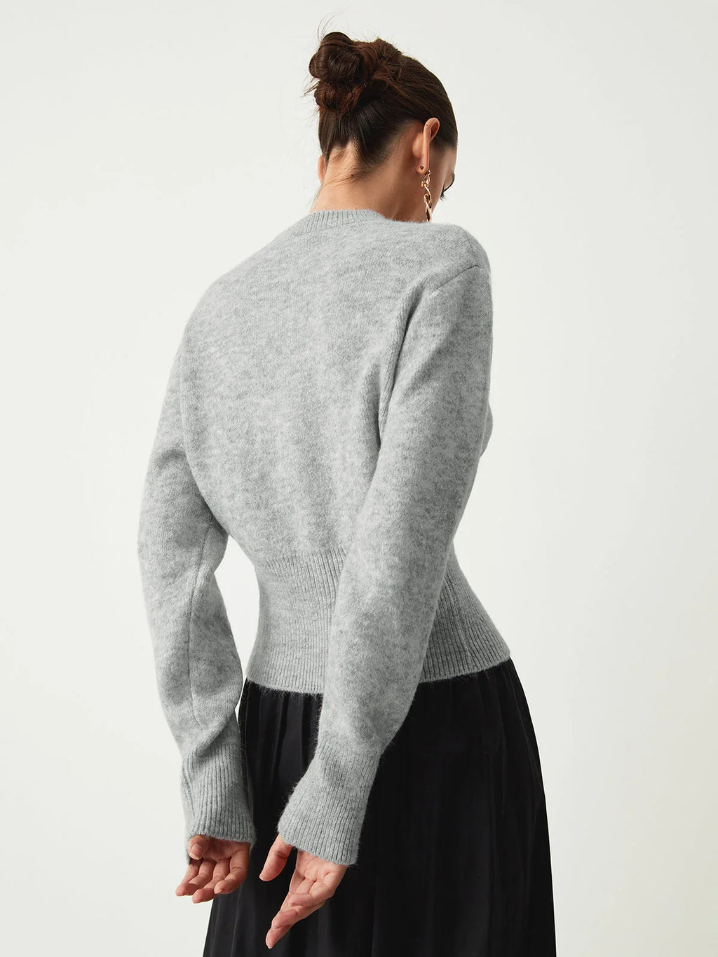 Pull gris femme avec demi-zip, manches longues et coupe décontractée en tissu doux.