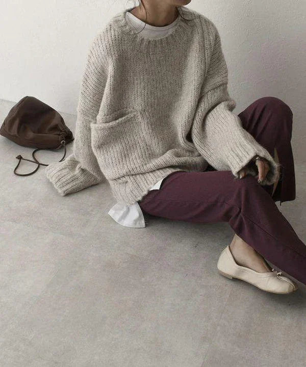 Pull oversize beige femme en matière douce, avec poche kangourou et coupe décontractée.