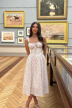 Robe midi blanche à fleurs, bretelles ajustables, en coton léger, parfaite pour un look estival décontracté.