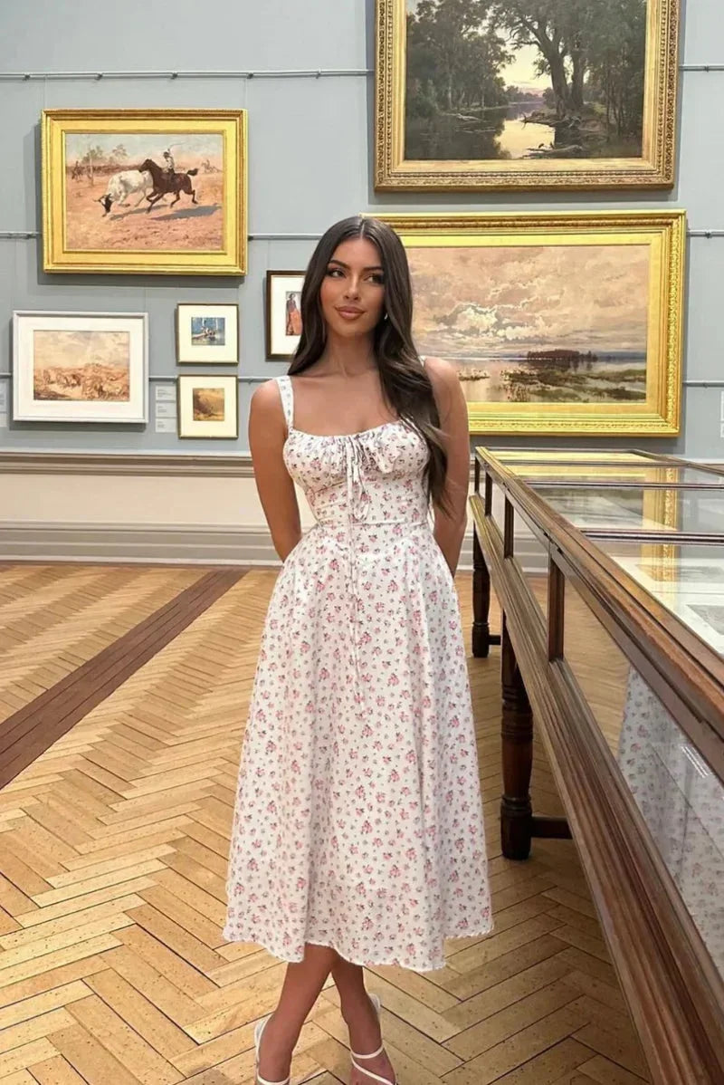 Robe midi blanche à fleurs, bretelles ajustables, en coton léger, parfaite pour un look estival décontracté.