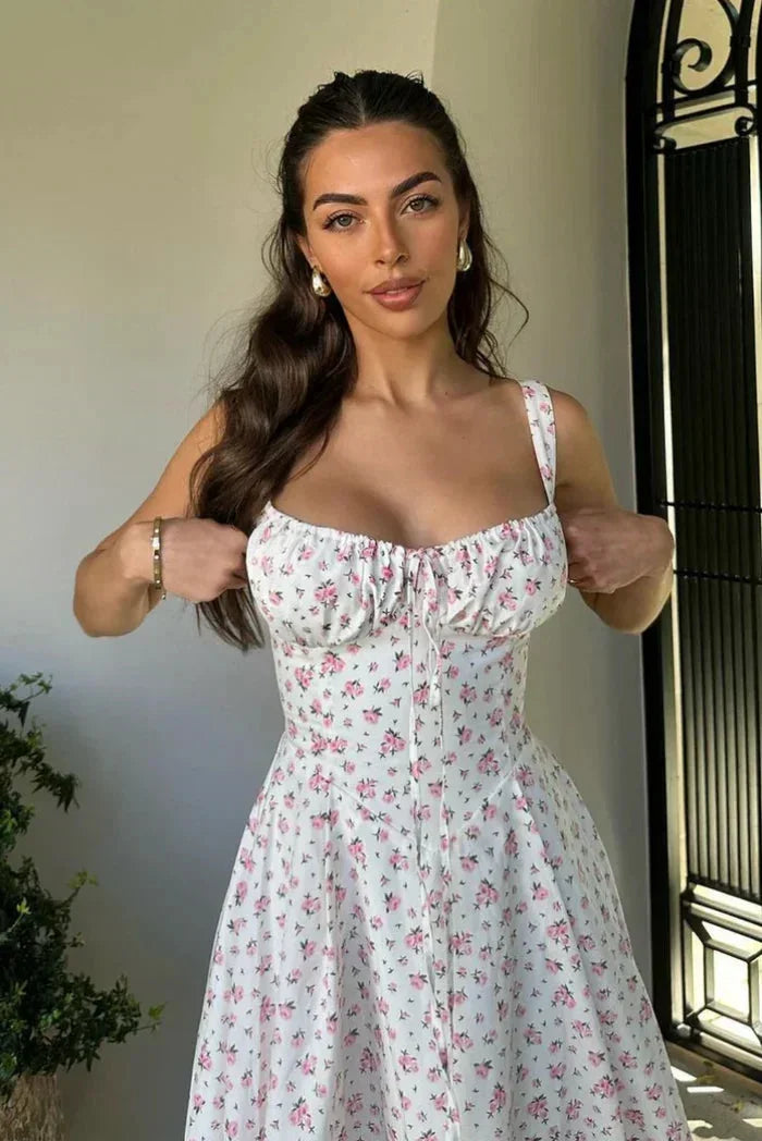 Robe midi blanche à fleurs avec bretelles, confectionnée en coton léger pour un look estival décontracté.