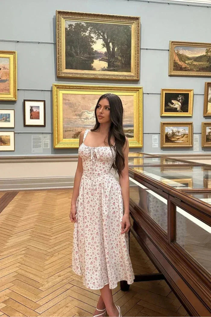 Robe midi blanche à fleurs avec bretelles, tissu léger, coupe ajustée au corset, idéale pour l’été décontracté.