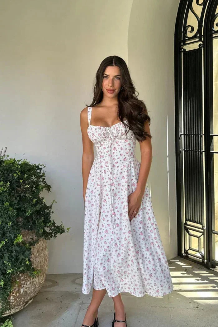 Robe midi blanche à bretelles avec motif floral, en coton léger, idéale pour un look estival décontracté.