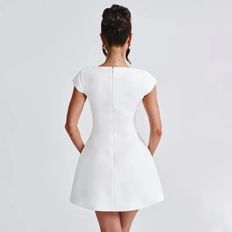 Robe courte blanche en coton avec encolure carrée et manches courtes, silhouette ajustée pour soirée élégante.