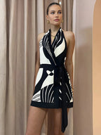 Robe courte cache-cœur sans manches, imprimée monochrome, idéale pour les soirées d'été, en tissu léger et fluide.