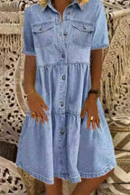 Robe courte en denim avec manches courtes, poches pratiques et fermeture boutonnée, idéale pour un style décontracté.