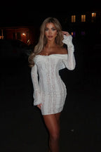 Robe courte en dentelle blanche, design à épaules dénudées et manches courtes, idéale pour les occasions estivales.