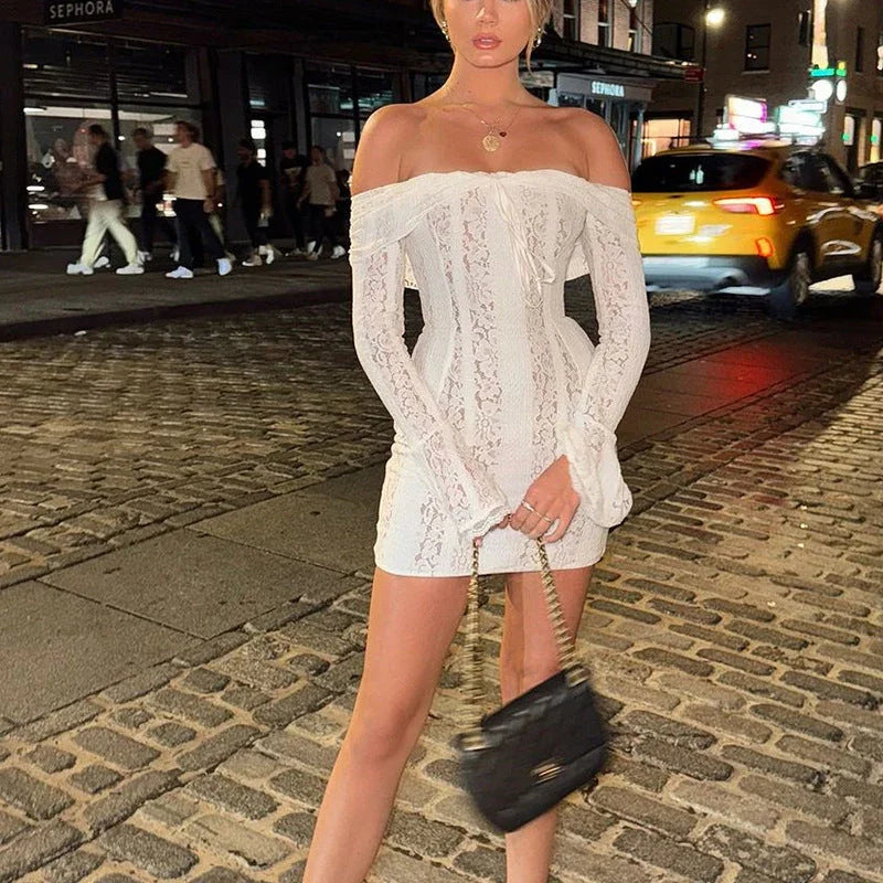 Robe courte blanche en dentelle, à épaules dénudées, avec une coupe délicate et des détails floraux.