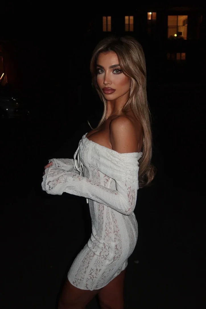 Robe courte en dentelle blanche avec épaules dénudées, élégamment conçue avec un tissu délicat et des détails floraux.