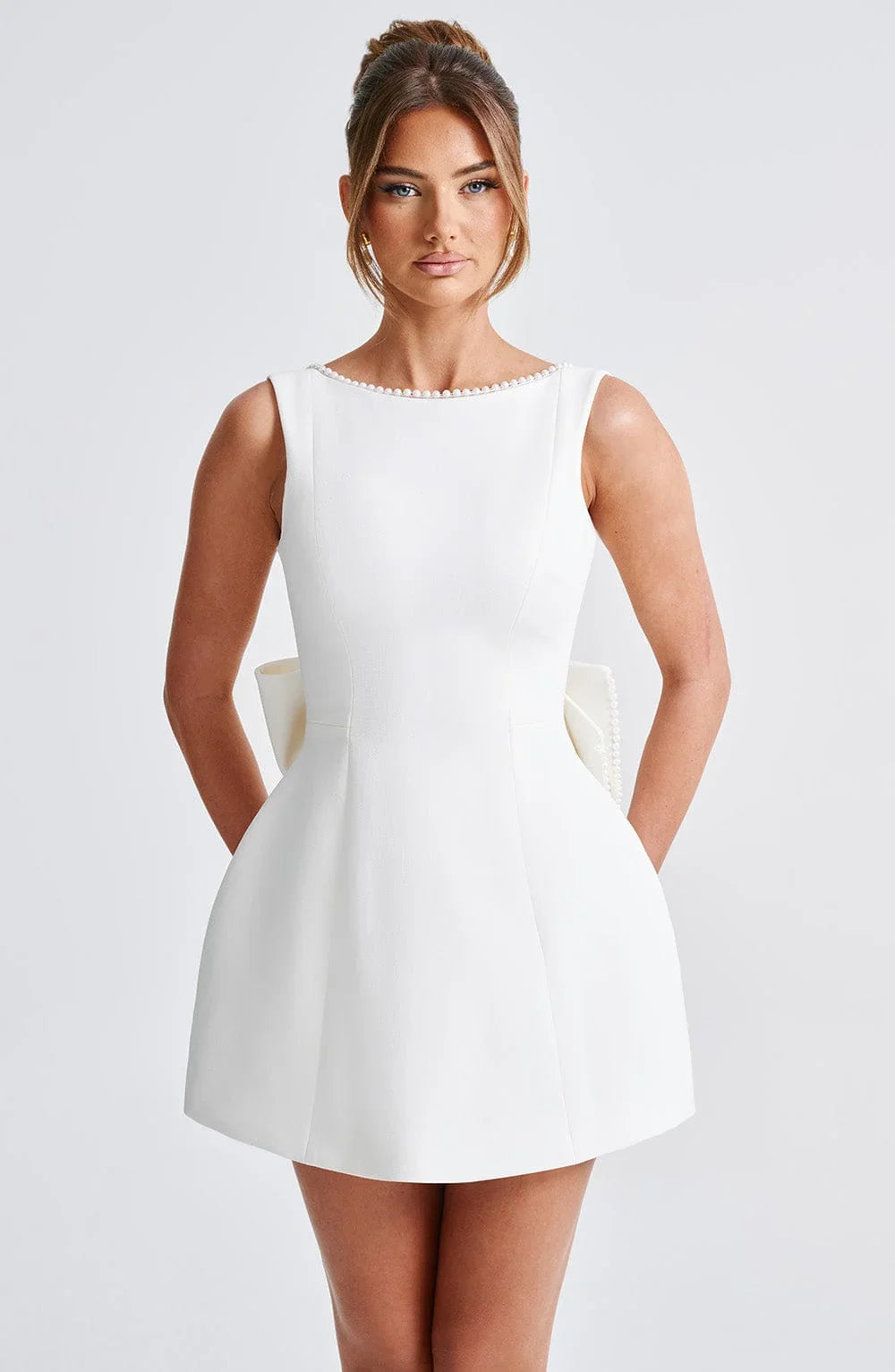 Robe courte femme en coton, avec nœud décoratif au dos et coupe moderne, idéale pour les occasions estivales.