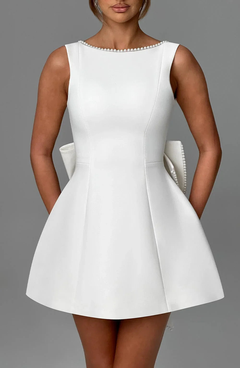 Robe courte femme en coton avec nœud décoratif au dos et manches courtes, idéale pour les occasions décontractées.