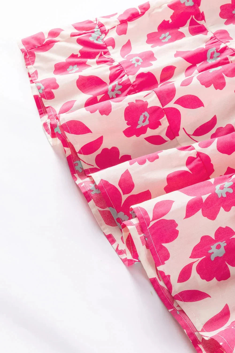 Robe courte fleurie rose, en coton léger, avec volants et manches bouffantes, idéale pour des journées d'été décontractées.