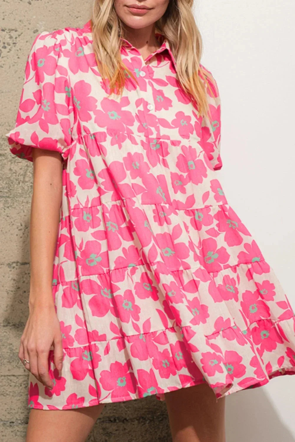 Robe courte en coton rose avec un motif floral, volants et manches bouffantes, idéale pour les journées d'été.
