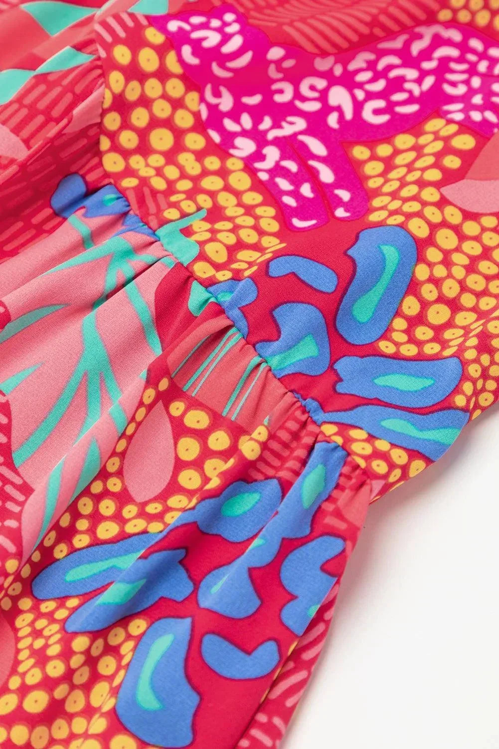 Robe courte rose vif à manches évasées, en tissu léger, avec un motif floral pour un look décontracté d'été.