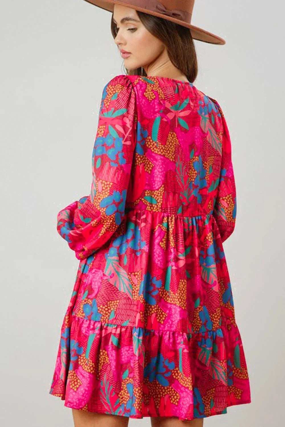 Robe courte rose vif à manches évasées, en tissu léger et fluide, idéale pour un look décontracté d'été.