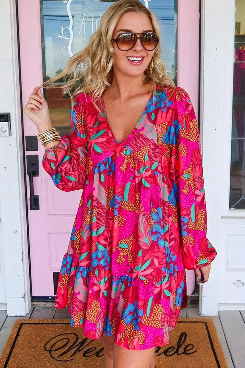 Robe courte rose vif en coton, avec manches évasées et imprimé floral, parfaite pour un look décontracté d'été.