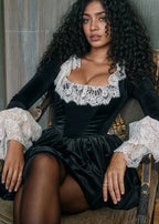 Robe courte noire en dentelle avec manches longues, col carré et jupe volumineuse, idéale pour les soirées élégantes.