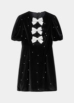 Robe courte à pois avec nœuds et manches bouffantes, en tissu léger, parfaite pour les soirées d'été.