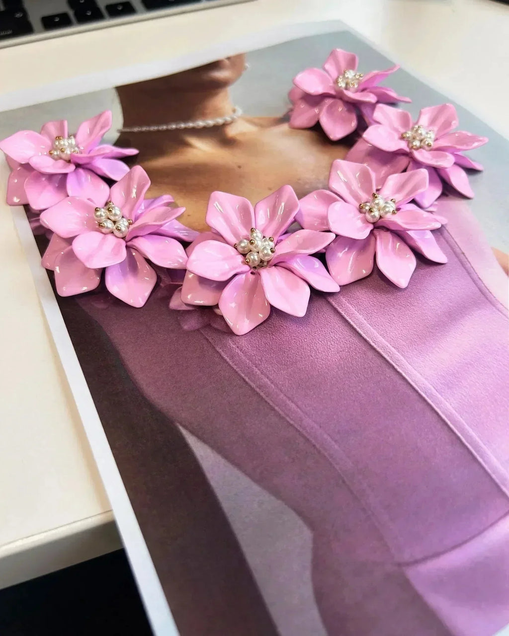 Robe courte rose sans manches avec détails floraux et encolure ajustée, parfaite pour les fêtes d'été.