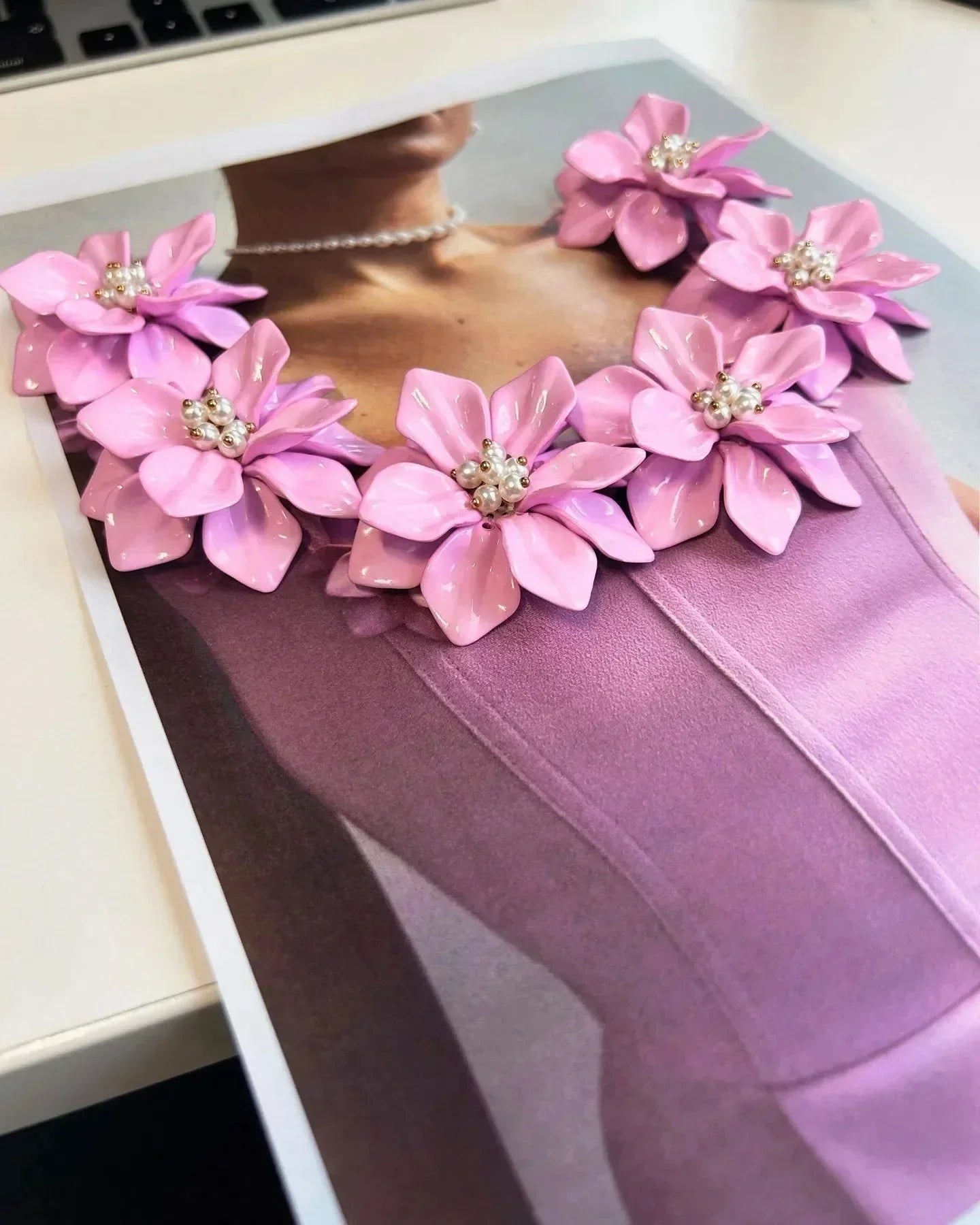 Robe courte rose sans manches avec détails floraux et encolure ajustée, parfaite pour les fêtes d'été.