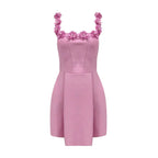 Robe courte rose sans manches avec encolure florale, en tissu léger, idéal pour les fêtes d'été. Détails floraux délicats.