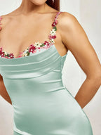 Robe longue ajustée sans manches en tissu léger, ornée de motifs floraux délicats pour une tenue élégante lors de soirées.